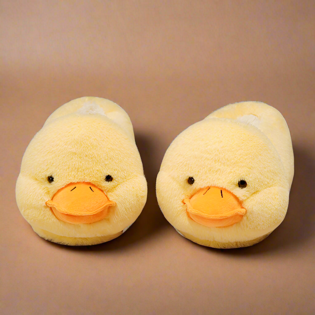 Fun duck-shaped slippers in soft yellow fabric with an orange beak and cozy lining, ideal for a playful, warm fit.