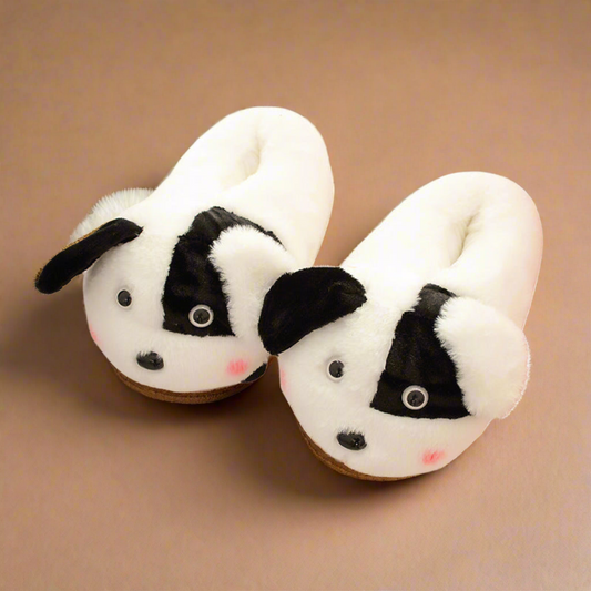 Black and white dog-shaped slippers with plush fur, 3D ears, and a friendly face, crafted for warmth and comfort.