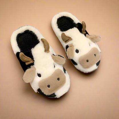 Cow-themed slippers with soft black and white plush, 3D ears and nose, designed for warmth and a fun animal look